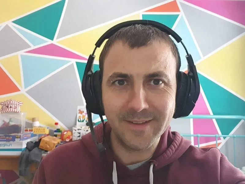 Paul in a kids bedroom with headset and painted geometric background